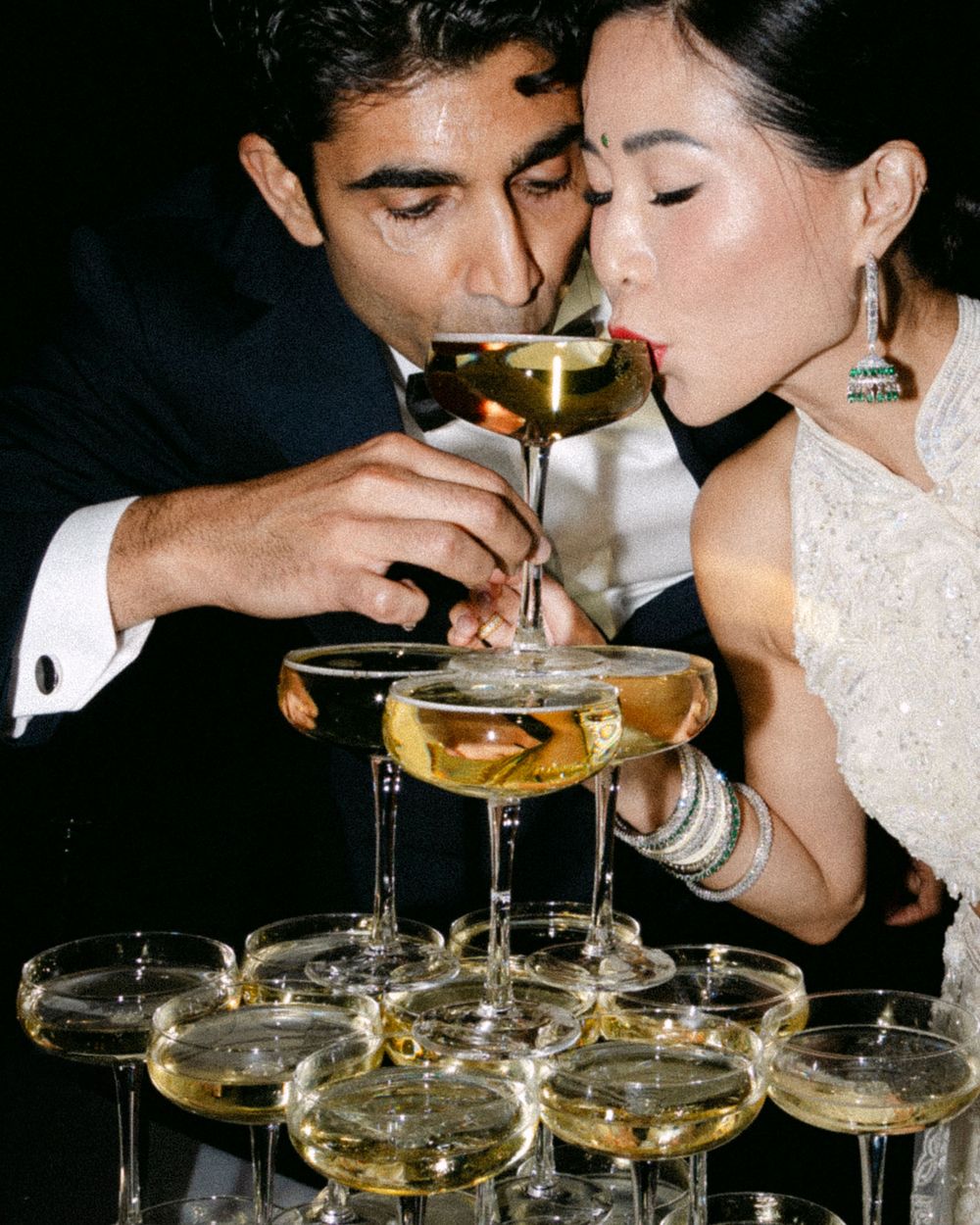 An elegant champagne tower pour captured during a wedding celebration.