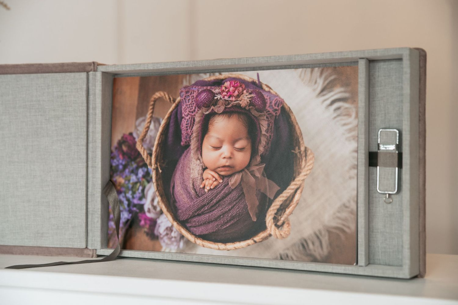 Artistic wall display featuring soft-toned newborn photography prints in a modern gallery arrangement.