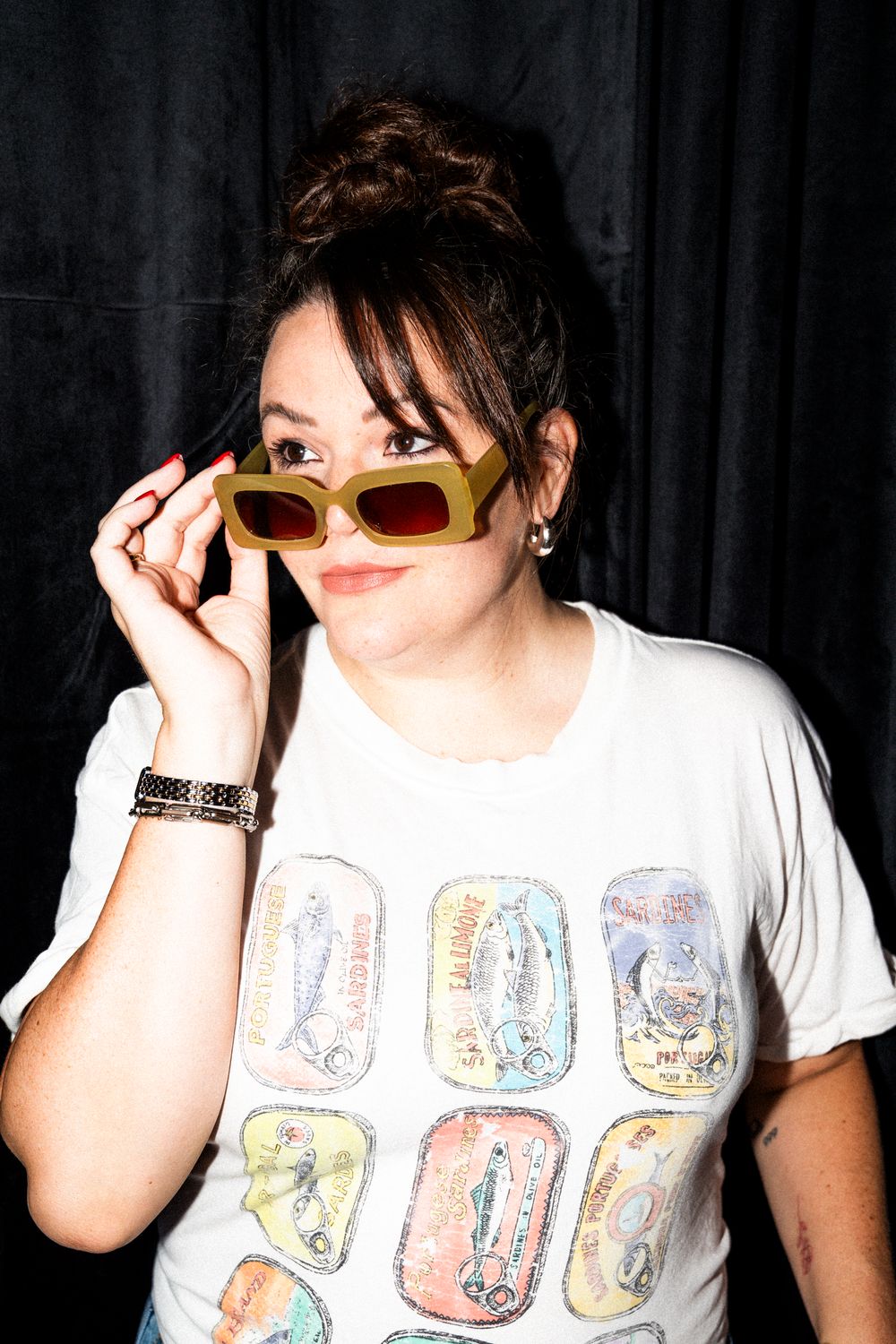 Figure wearing sunglasses and printed t-shirt strikes casual poses in sequence against black backdrop.