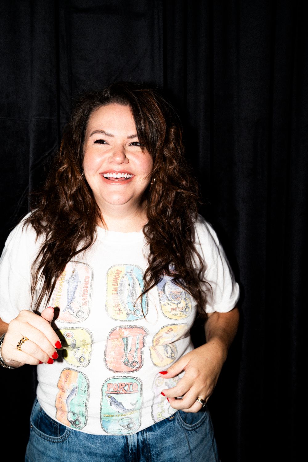 A series of flash photos showing someone in a white graphic t-shirt and jeans making expressive poses against a dark background.