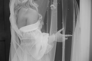 Black and white image of a woman in evening wear walking through a doorway in seductive poses across multiple frames.
