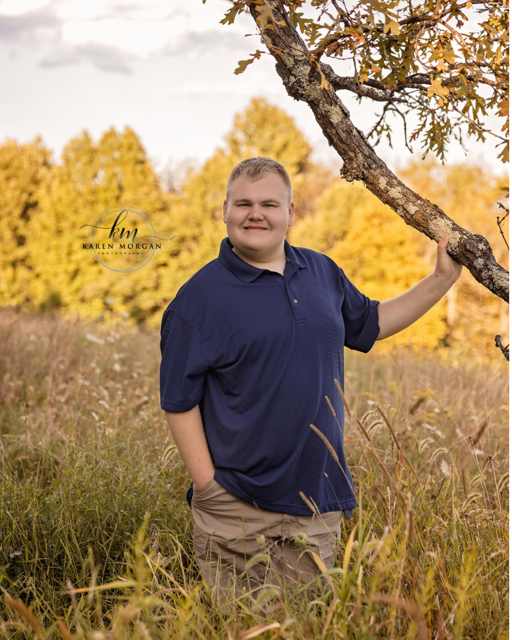 Casual outdoor portrait session in a field with tall grass and autumn colors.