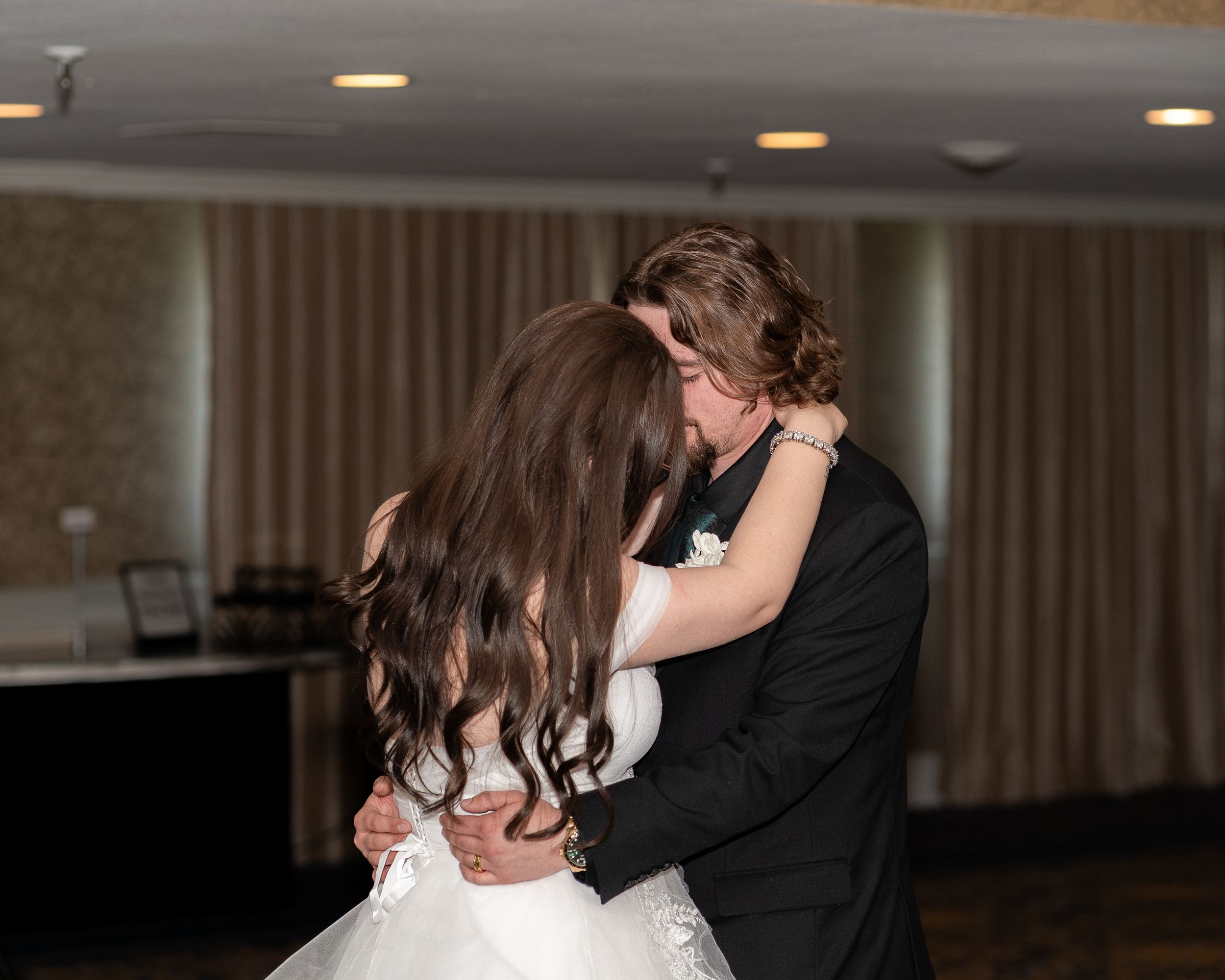A romantic moment on the dance floor as two people embrace during what appears to be their wedding dance.