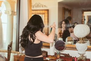 Multiple vanity mirrors and reflections in an ornate room with warm lighting.