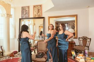 Getting ready scene with blue bridesmaid dresses in an elegant indoor setting.
