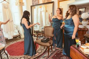 Group preparing for a wedding celebration in a sunlit room with ornate furnishings.