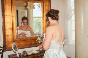 Vintage-style wooden vanity mirror in a room with natural lighting.