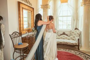Elegant room with large windows and vintage furniture during wedding preparations.