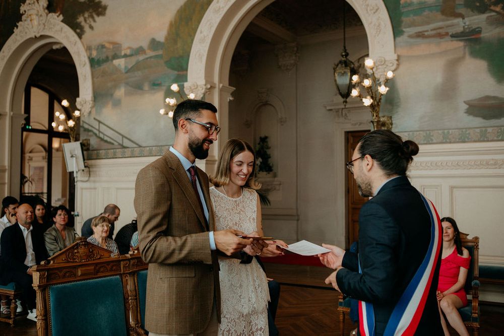 Couple exchanges vows during a civil wedding ceremony in a beautifully decorated hall.