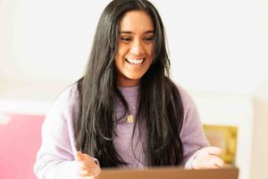 young woman on a computer call, smiling