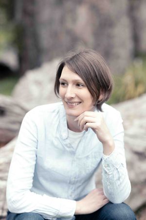 woman sitting on log looking to the side