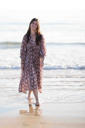 Young woman in long flowing dress at the beach