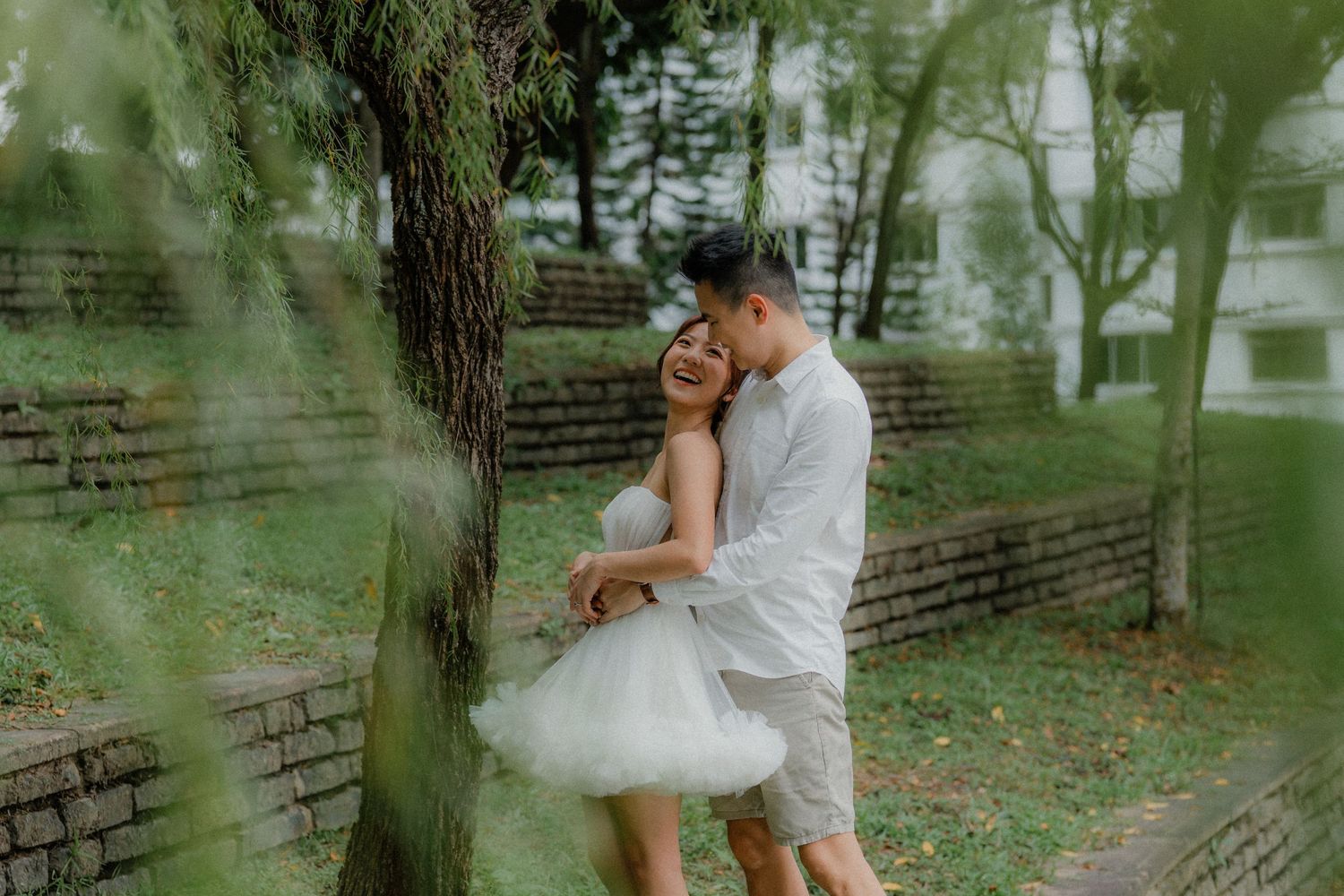 Romantic moment at a park playground with swings and trees in the background.