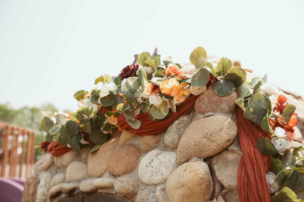 A rustic brick wall adorned with an elegant cascade of peach roses and white flowers in an outdoor setting.