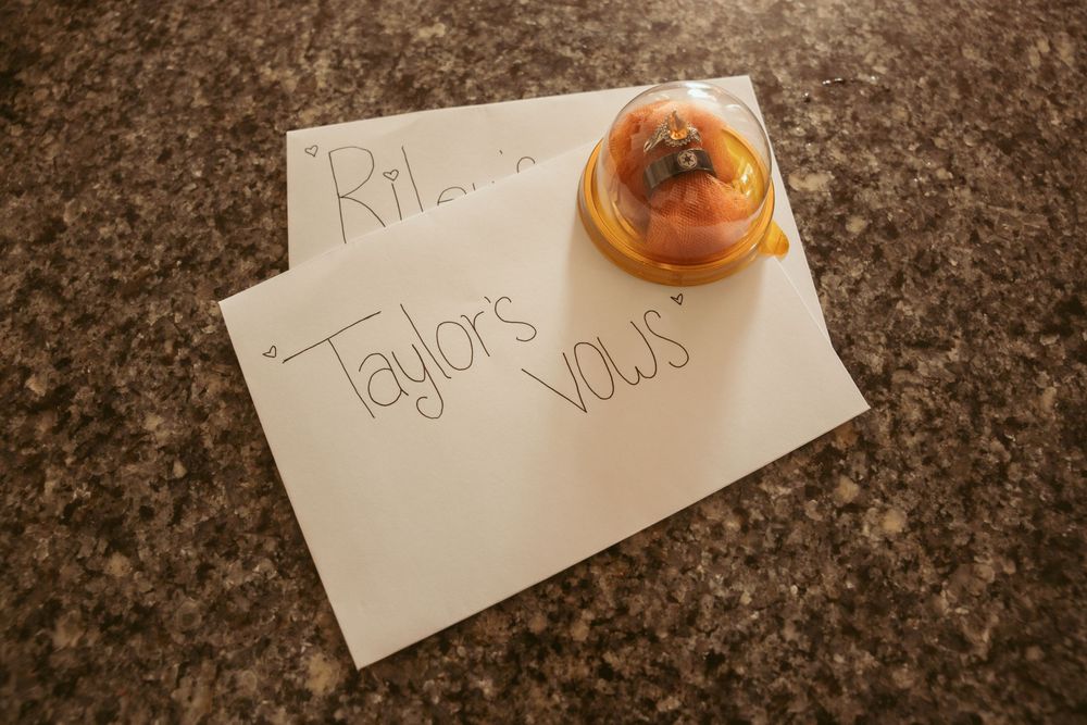 Handwritten wedding vow cards with a persimmon on granite countertop.