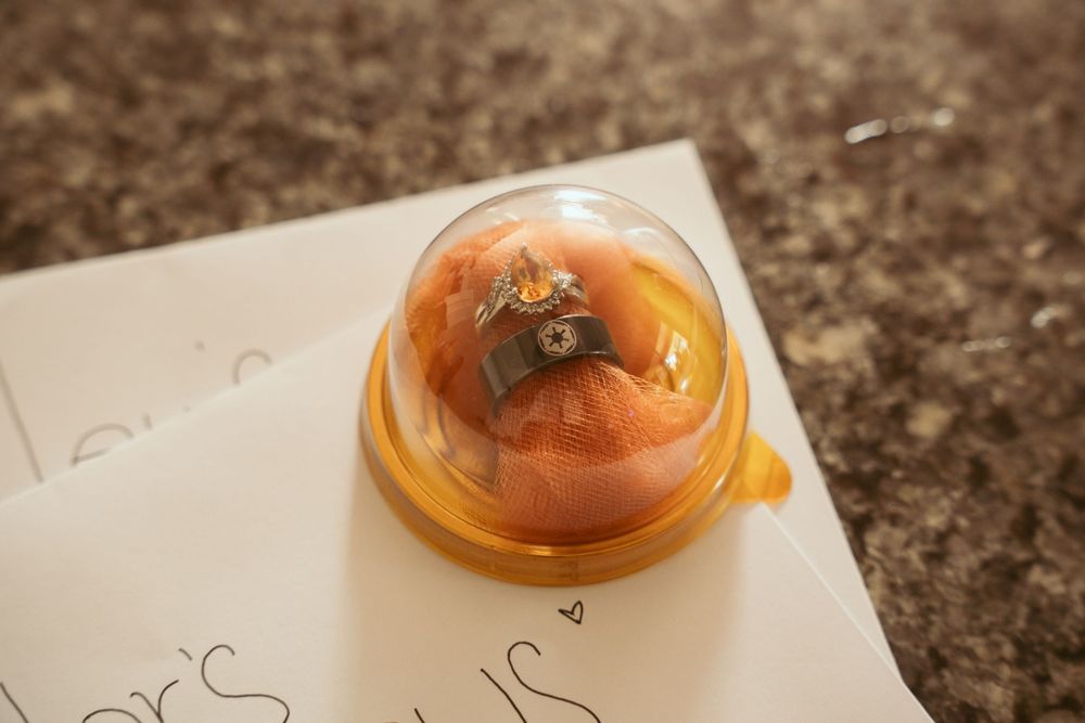 Close-up of wax seals and vintage-style wedding stationery on dark marble surface.