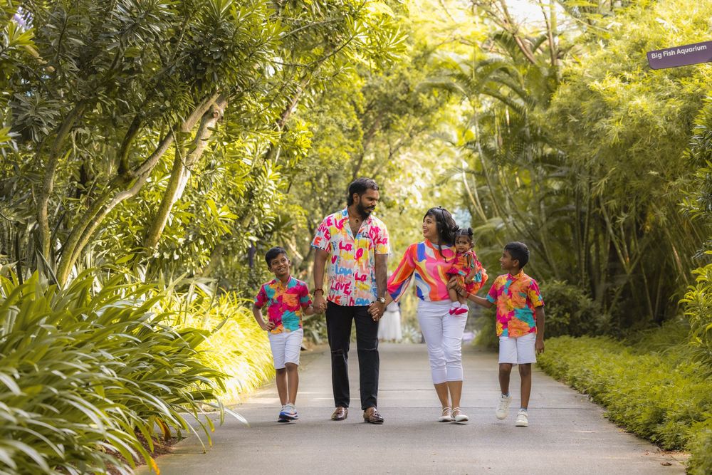 A pastoral walking path through lush greenery shows a group of people strolling in matching red and white attire.