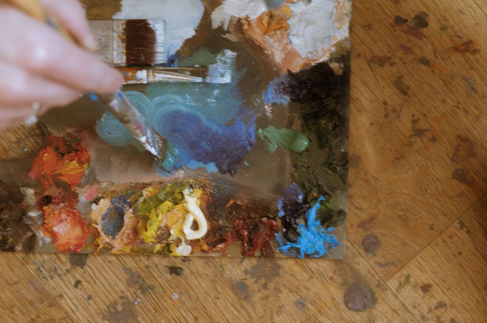 Sesja fotograficzna w atelier malarskim, paleta malarska, pędzel, detale malarskie.