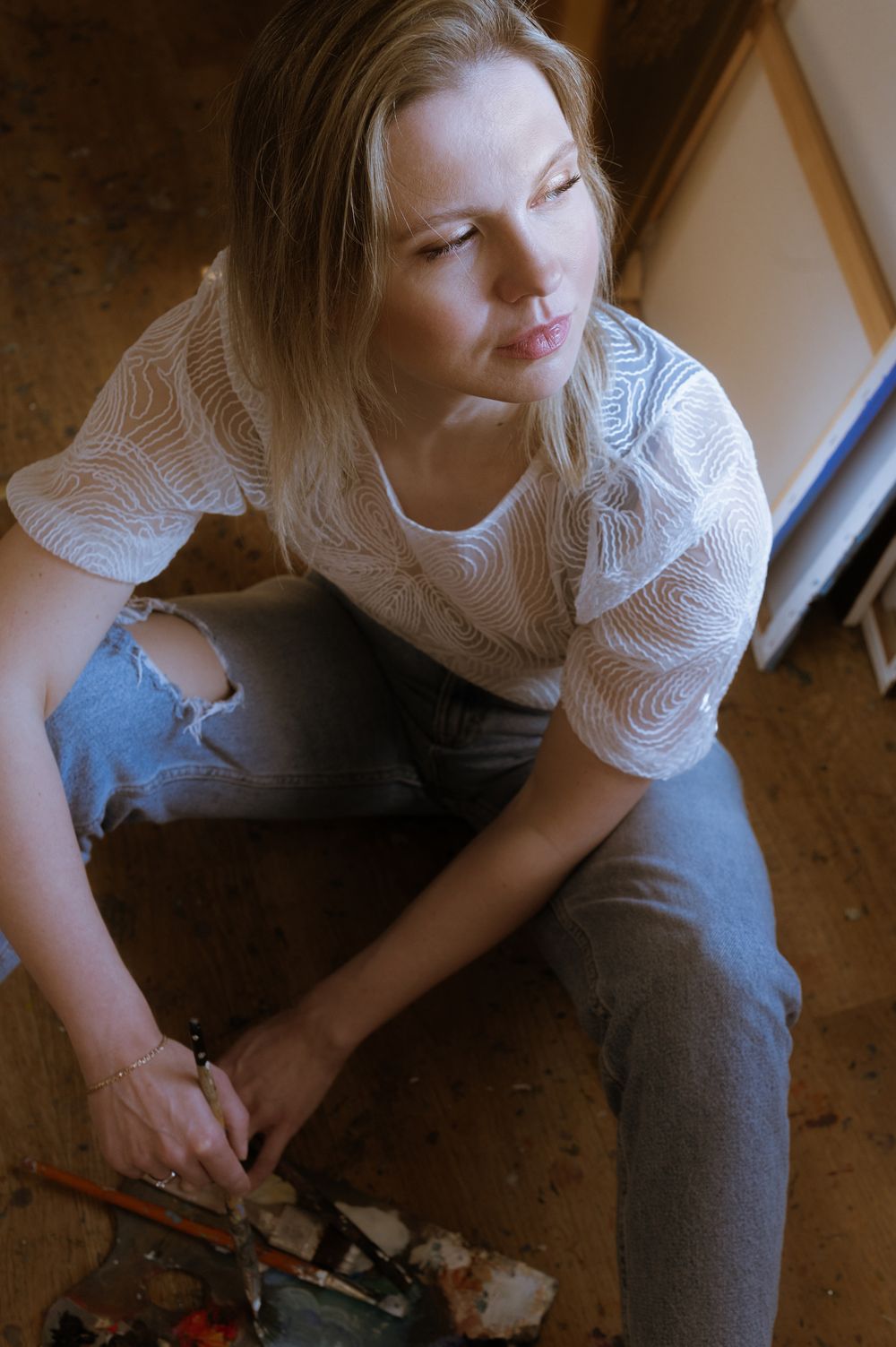 Portret kobiety przy oknie w subtelnym, naturalnym oświetleniu.