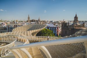 Metropol Parasol wooden structure overlooks historic Seville skyline with church spires and buildings on sunny day.