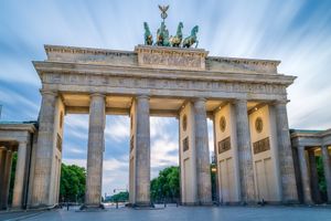 The iconic Brandenburg Gate in Berlin stands majestically against a blue and cloudy sky during daytime.