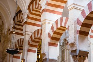 Architectural detail showing red and white striped horseshoe arches in the historic Mezquita mosque-cathedral of Cordoba.