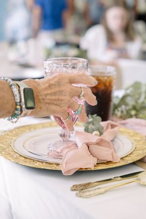 Gold charger plates with delicate pink origami butterfly napkin decorations create an elegant table setting.