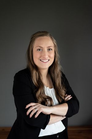 Professional headshot portraits against dark background showing warm expressions and casual business attire.