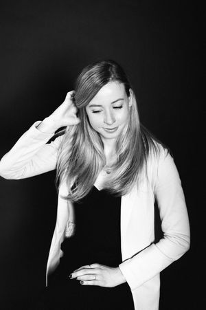 Artistic black and white photo sequence showing a person in white top looking down with graceful movements against dark backdrop.