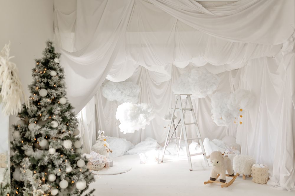 Decorative white drapes with romantic lighting create an ethereal ambiance for a holiday party or winter wedding setting.