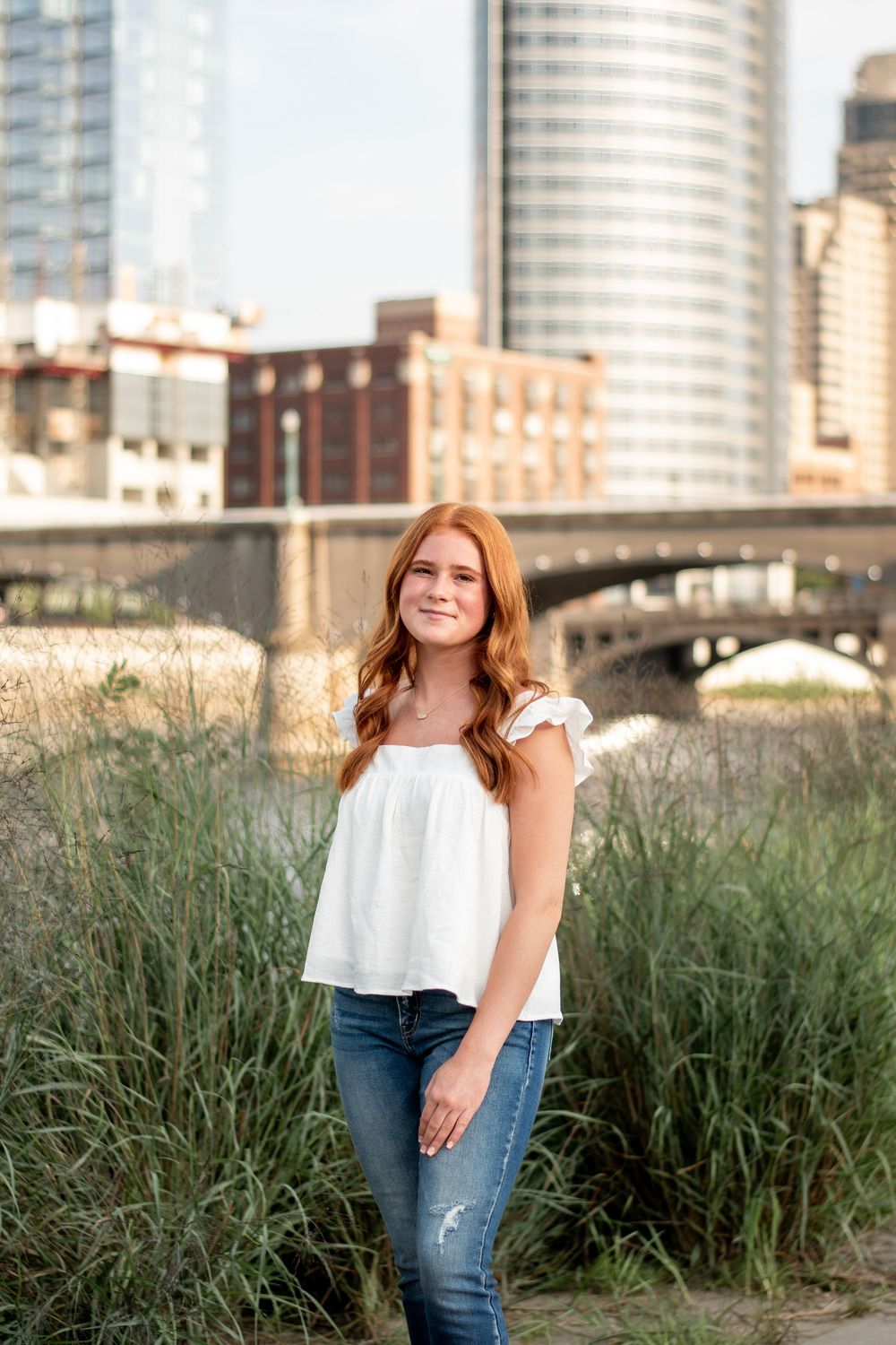 Senior girl posing with the Grand Rapids skyline in the background.