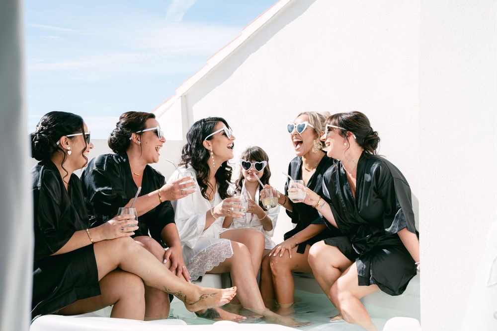 Group wearing black and white clothing lounges together in a casual photoshoot setting.