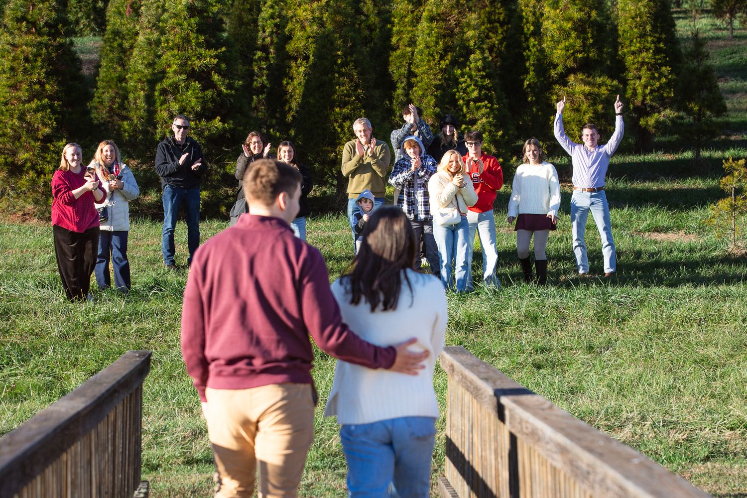 A group of people cheering together for the surprise proposal