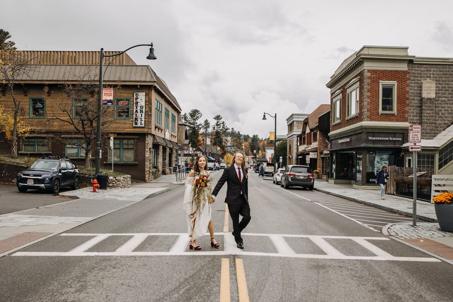 couple walking through lake placid on their wedding day