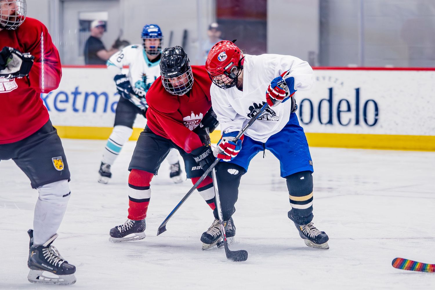 Two competing hockey athletes at Chicago Pride Hockey's Market Days Classic tournament fight for control over the puck