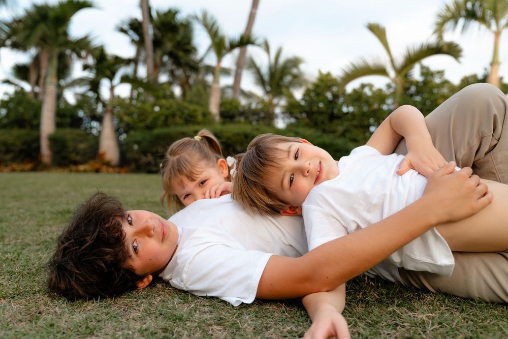 Candid lifestyle photos showing intimate moments of people laying on grass in casual white outfits.