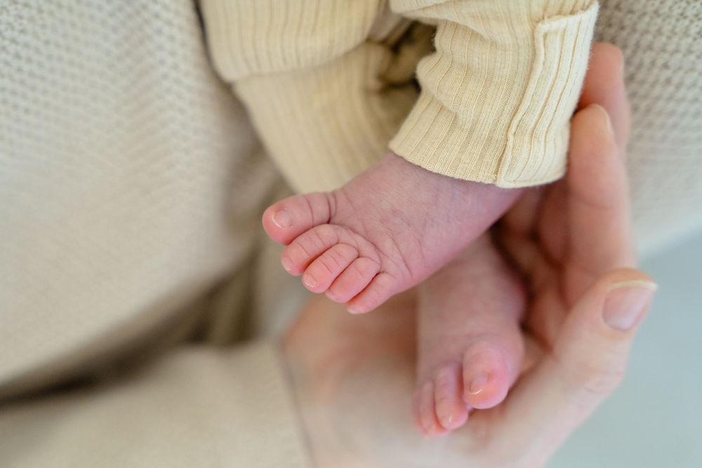 A series of close-up photos showing tiny baby feet being gently held by adult hands.