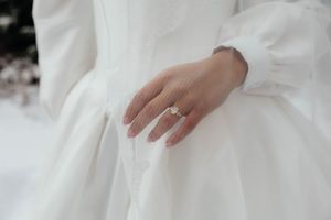 Close-up details of a white wedding dress with delicate fabric and lace elements.