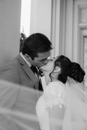 An intimate black and white wedding portrait capturing a tender kiss.