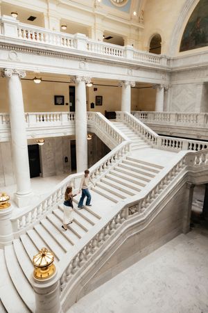 A grand staircase with ornate columns and balconies in a historic building.