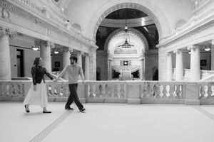 A grand, ornate interior with arched doorways and people walking through the hall.