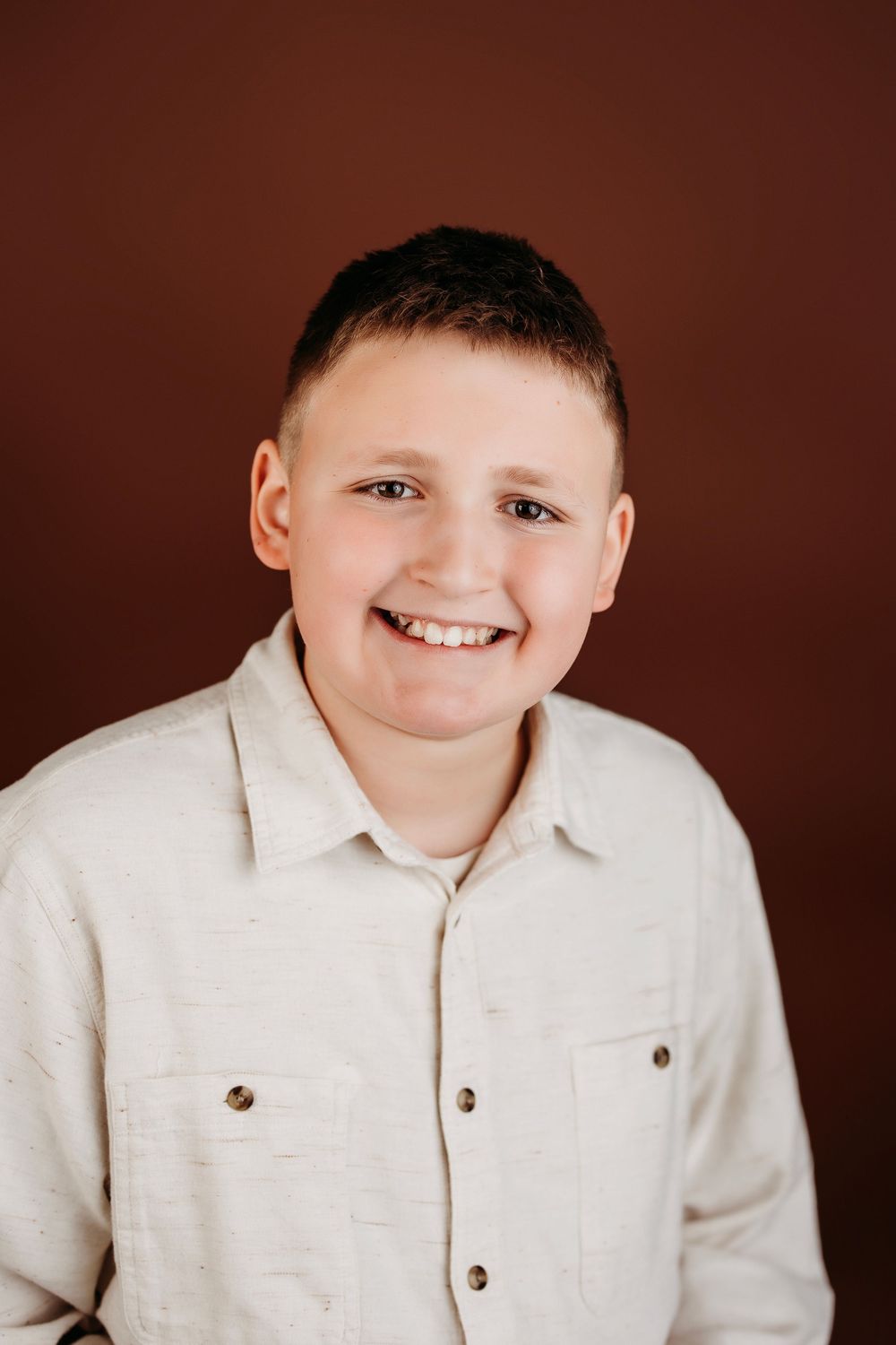 Studio portrait series showing joyful expressions against brown background wearing light colored clothing.