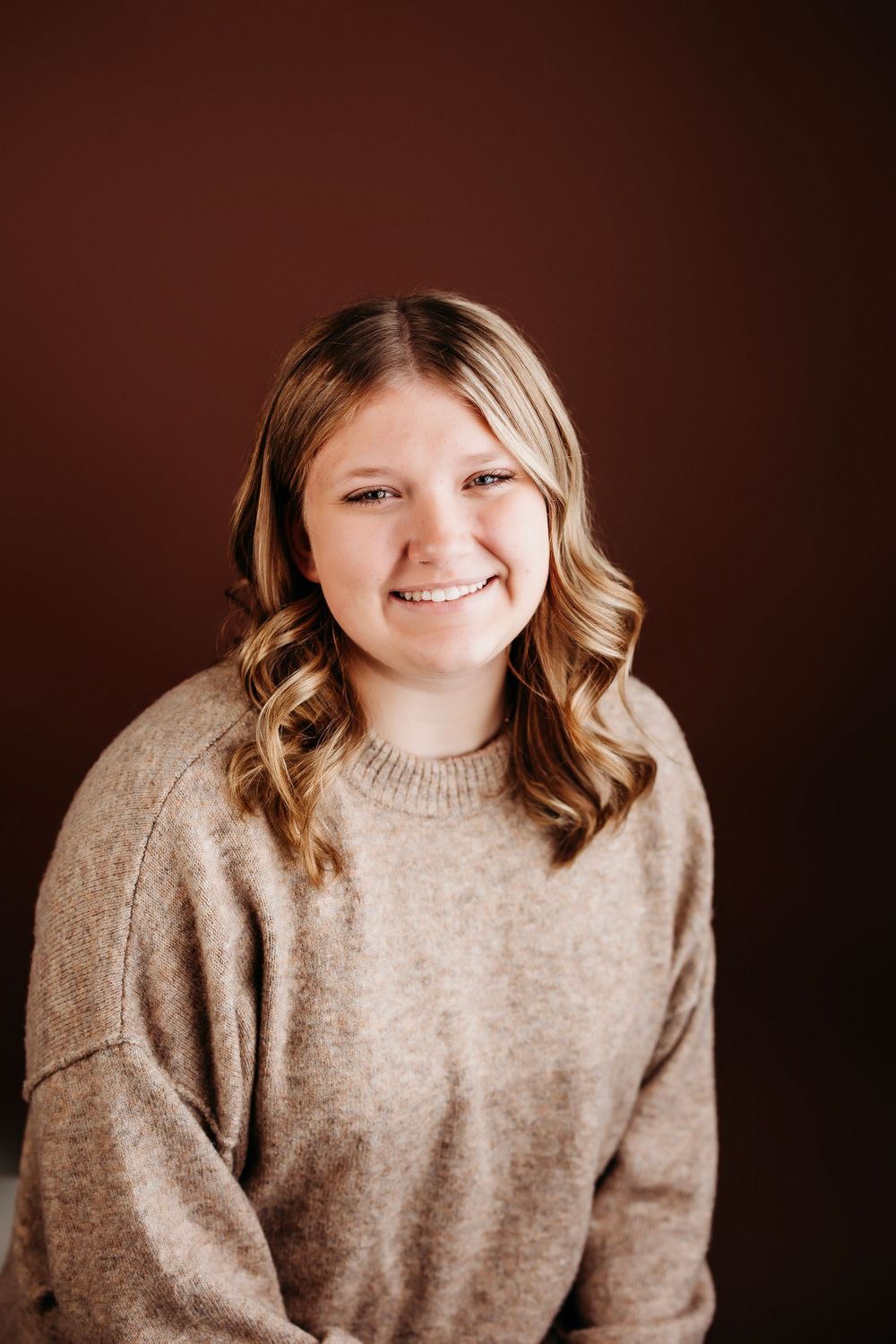 Portrait series showing someone in a beige sweater against dark background with warm lighting.