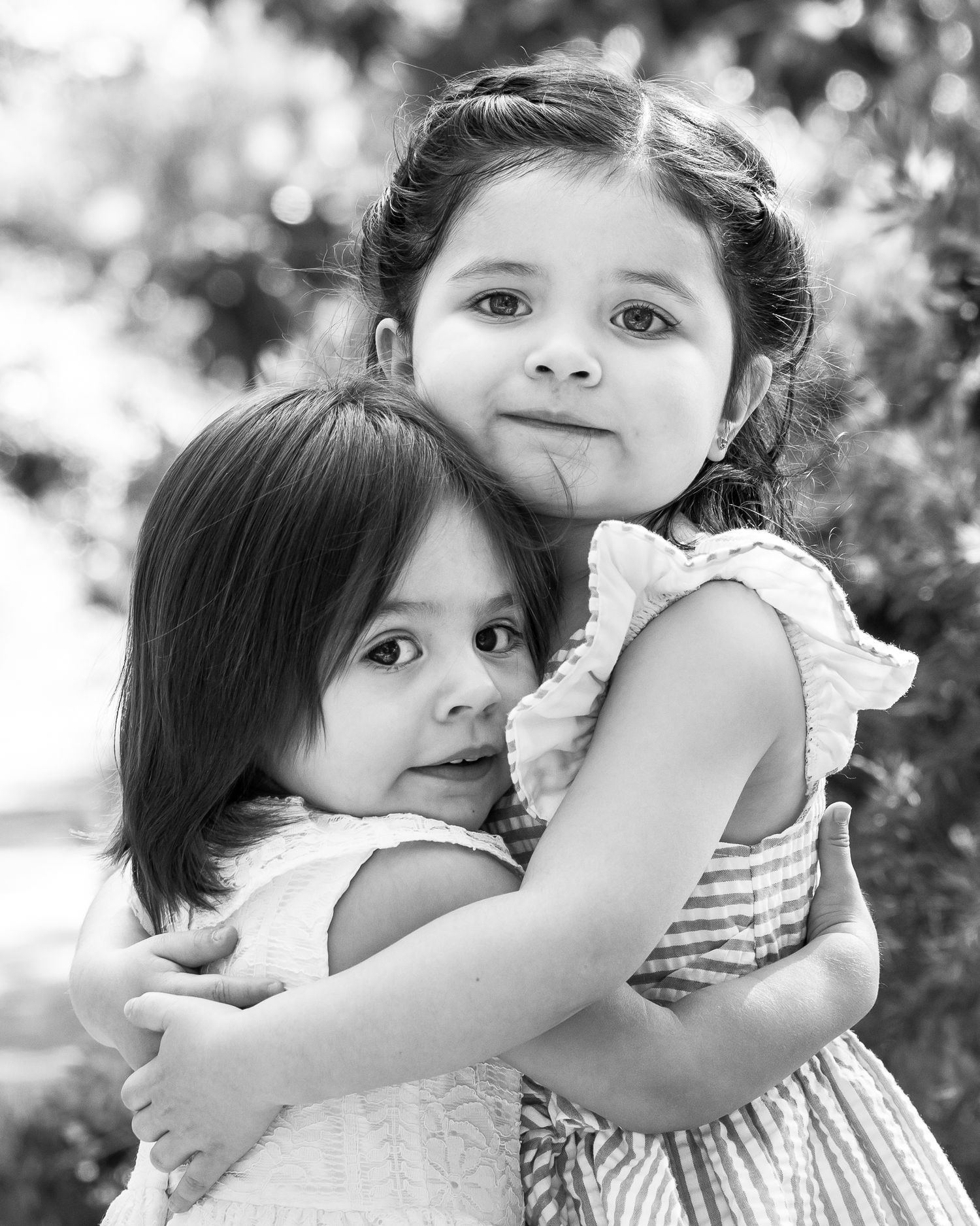 Close crop of two little girls tightly hugging. (black and white) Doughman Photography