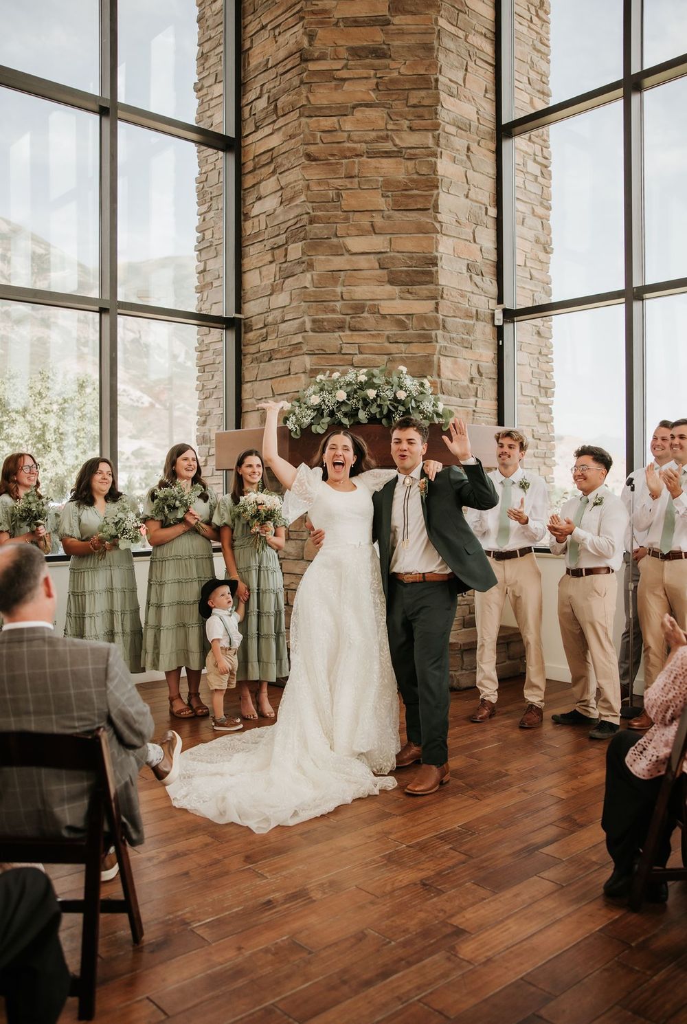 utah county Wedding ceremony in elegant venue with stone walls and large windows.