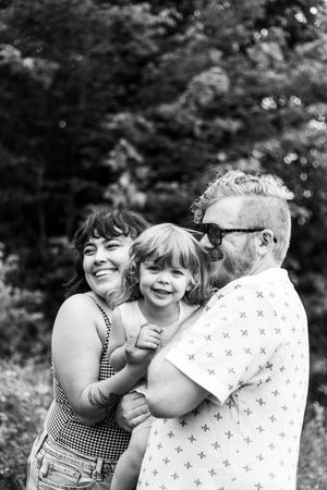 Black and white candid shots of joyful family moments outdoors.