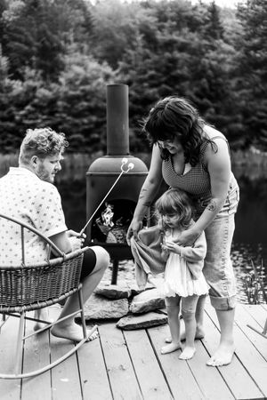 Black and white photo sequence showing people sitting on a wooden dock by a lake with a picnic basket.