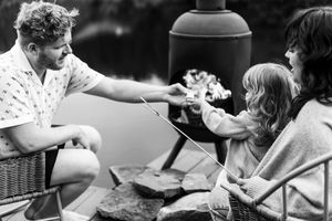 Black and white sequence of people relaxing and enjoying time together on a lakeside dock.
