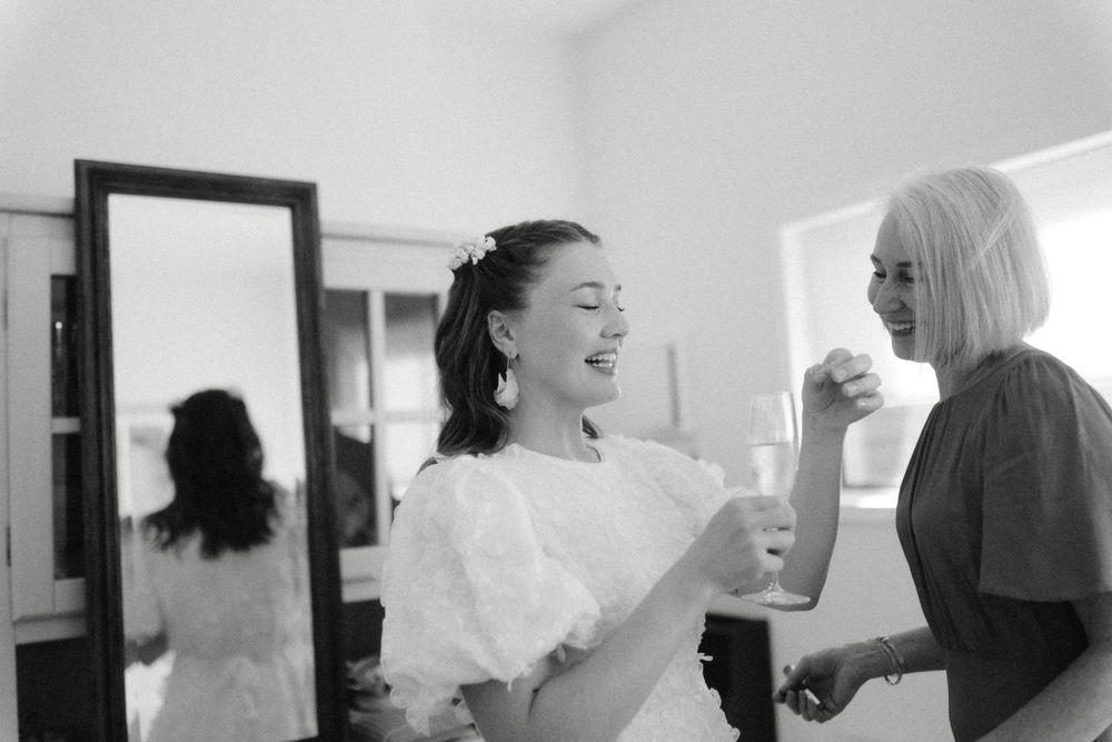 Series of black and white images showing spontaneous laughter during wedding day preparations.