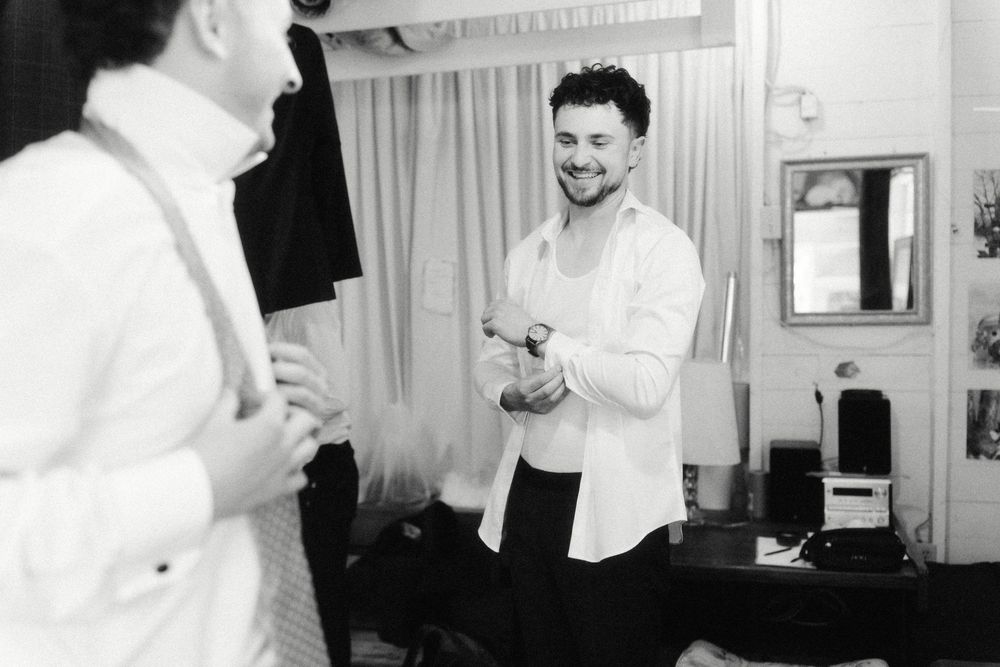 Candid black and white shots capture laughter and preparation moments in a bright indoor setting.